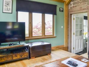 a living room with a television on a table at Greve Cottage in Marykirk