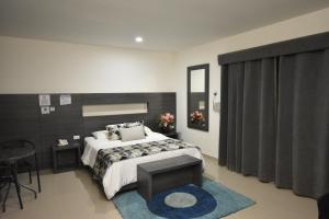 sypialnia z dużym łóżkiem i niebieskim dywanem w obiekcie Hotel La Casa N. 3 w mieście Montería