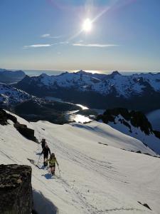 Dos personas esquiando por una montaña cubierta de nieve en Unique and charming house at the foot of Lofoten's highest mountain, en Svolvær
