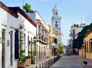 JM GUESTHOUSE في سانتو دومينغو: شارع المدينة مع برج الساعة في المسافة