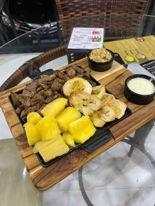 a tray of food with pineapple and meat on a table at HOTEL IMPERIO in Aparecida do Taboado