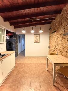 een keuken met een tafel en een stenen muur bij El Alegato Casa de Invitados in Antigua