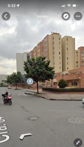 una motocicleta estacionada en un estacionamiento con edificios en Acogedor apartamento en zona corporativa Ciudad Salitre en Bogotá
