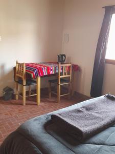 ein Raum mit einem Tisch mit einer Decke darauf in der Unterkunft ElPoro in Purmamarca