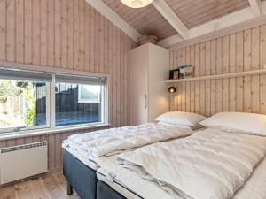 ÅlbækにあるThree-Bedroom Holiday home in Ålbæk 56のベッドルーム1室(大型ベッド1台、窓付)