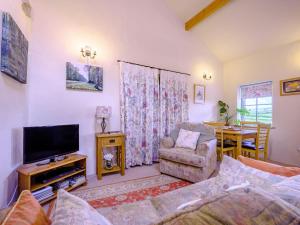 uma sala de estar com um sofá e uma televisão em Pickle Cottage em Carnforth