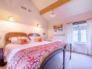 um quarto com uma cama grande e uma janela em Pickle Cottage em Carnforth