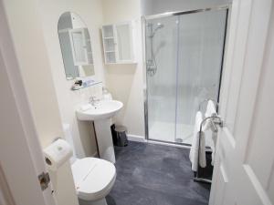 a bathroom with a shower and a toilet and a sink at APL Apartments in Aberdeen