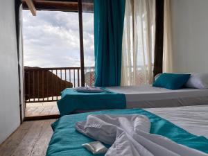 two beds in a room with a balcony at Cabaña The Sunset in Santa Marta