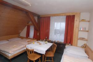 ロウチュナー・ポト・クリーノヴツェムにあるHorský Hotel Arnicaのベッド2台、テーブル、椅子が備わる客室です。