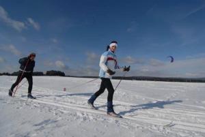 two people are cross country skiing in the snow at Horský Hotel Arnica in Loučná pod Klínovcem