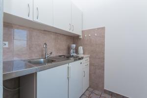 a kitchen with white cabinets and a sink at Apartment Brela 2717c in Brela