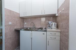 - une cuisine avec des placards blancs et un évier dans l'établissement Apartment Brela 2717c, à Brela