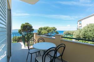 a balcony with a table and chairs and the ocean at Apartment Brela 2717c in Brela