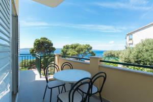 d'un balcon avec une table et des chaises donnant sur l'océan. dans l'établissement Apartment Brela 2717c, à Brela