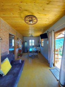 a living room with a couch and a ceiling at Chalé Alto da Serra in Gonçalves
