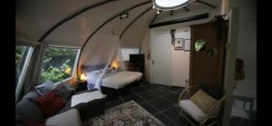 a room with a bedroom with a bed and a couch at Unique private guesthouse 'The Iglo' in Paterswolde