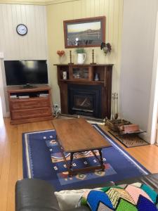 a living room with a coffee table and a tv at Rosellas on Corundum Cottage - treat yourself! in Stanthorpe