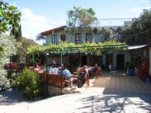 un grupo de personas sentadas en un restaurante al aire libre en St. Nicholas Pension en Patara