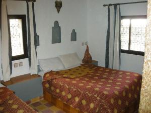 メルズーガにあるLes Portes Du Desertのベッドと2つの窓がある寝室