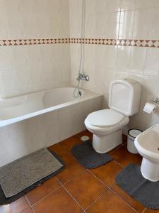 uma casa de banho com um WC, uma banheira e um lavatório. em Travelers House em Setúbal