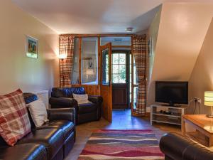 a living room with a couch and a tv at Poppy Cottage - Uk40102 in Dunvant