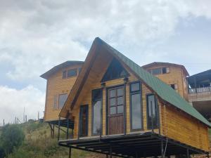 a house with a green roof on top of a hill at Playa Blanca - Glamping Bethél in Tota