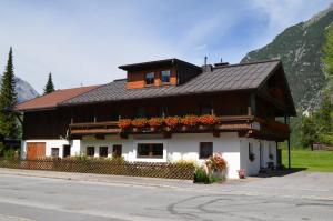 una casa con flores al lado de la calle en Lärchenhof, en Leutasch