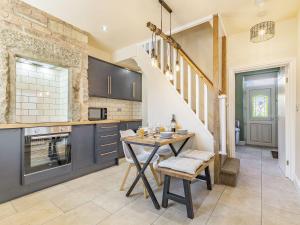 a kitchen with a table and chairs in a room at Spa Cottage in Bakewell