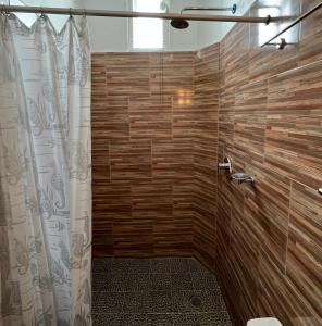 a bathroom with a shower with a wooden wall at Casa Lomas del Marinero Internet Starlink SIN GARAJE in Puerto Escondido +100 photos