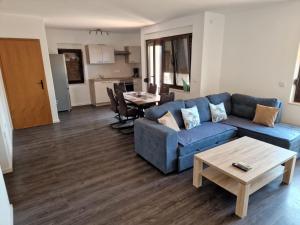 a living room with a blue couch and a table at Villa Bravo in Podstrana