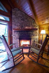 two rocking chairs in front of a stone fireplace at Gatlinburg Adventure Cabins in Sevierville