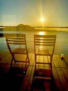 duas cadeiras sentadas numa doca perto da água ao pôr-do-sol em Côte terrasse onomichi - Vacation STAY 92432v em Onomichi