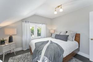a white bedroom with a bed and a window at Beautiful, Historic Home, heart of McMinnville. in McMinnville