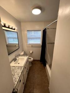 y baño con lavabo, aseo y espejo. en Modern 3-Bedroom Home with Cal-Kings Beds, 
