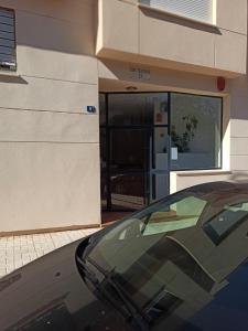 un coche aparcado frente a un edificio con garaje en Apartamento Teatinos Universidad en Málaga