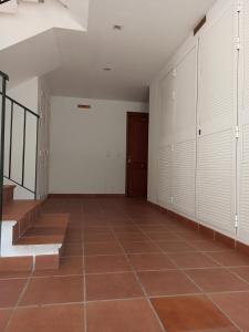 Habitación vacía con armarios blancos y suelo de baldosa. en Apartamento Teatinos Universidad en Málaga