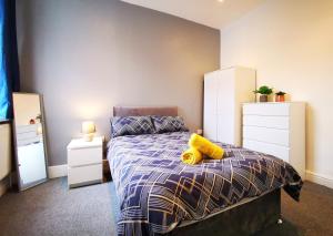 a bedroom with a bed with a yellow pillow on it at Spacious Townhouse 5 Mins to Liverpool City Centre With Free Parking in Liverpool