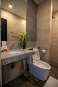 a bathroom with a toilet and a sink at Viven Hotel in Laoag