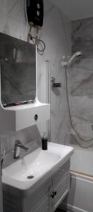 Yof的住宿－Résidence Safie，浴室配有白色水槽和淋浴。
