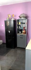 Yof的住宿－Résidence Safie，厨房配有紫色墙壁上的黑色冰箱