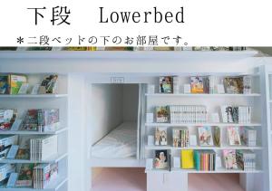 ein Bett in einem Bücherregal mit Büchern in der Unterkunft MANGA ART HOTEL, TOKYO in Tokio