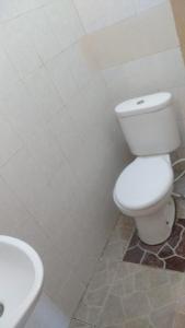 uma casa de banho com um WC branco e um lavatório. em Roejas Sunset em Uluwatu