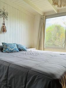 een bed in een kamer met een groot raam bij Casa en el Delta de Tigre puraisladelta in Tigre