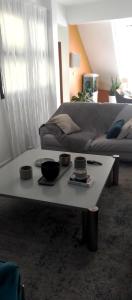 - Mesa de centro blanca en la sala de estar con sofá en Résidence Safie, en Yof