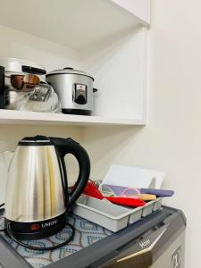 a tea kettle sitting on top of a kitchen counter at Spacious 2 bedroom 42sqm condo unit in Iloilo City