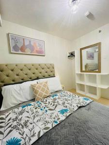 a bedroom with a large bed with a large headboard at Spacious 2 bedroom 42sqm condo unit in Iloilo City