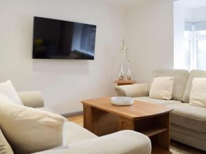 a living room with two couches and a coffee table at Princess Court Apartment in Llanelli