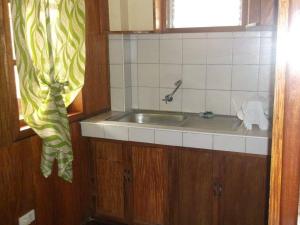 a kitchen with a sink and a window at Nellie's Tourist Inn- Port Barton in San Vicente