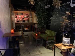 a room with tables and chairs and a bar at Hostel Bedgasm in Tokyo